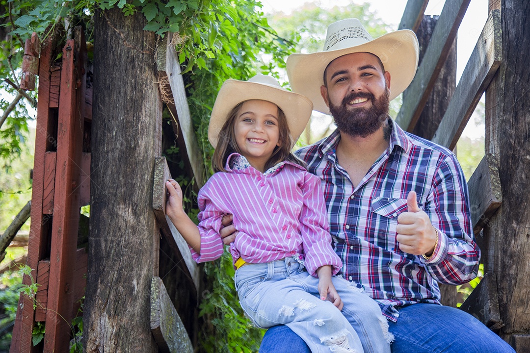 Pai fazendeiro ao lado de sua filha sobre fazenda