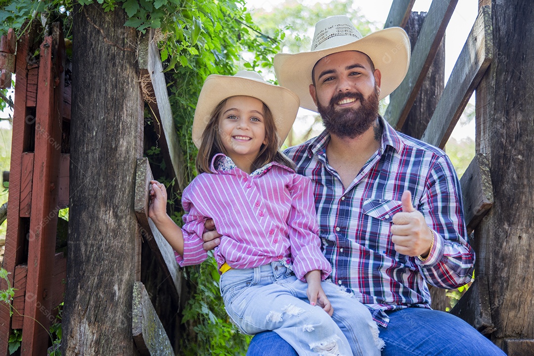 Pai fazendeiro ao lado de sua filha sobre fazenda