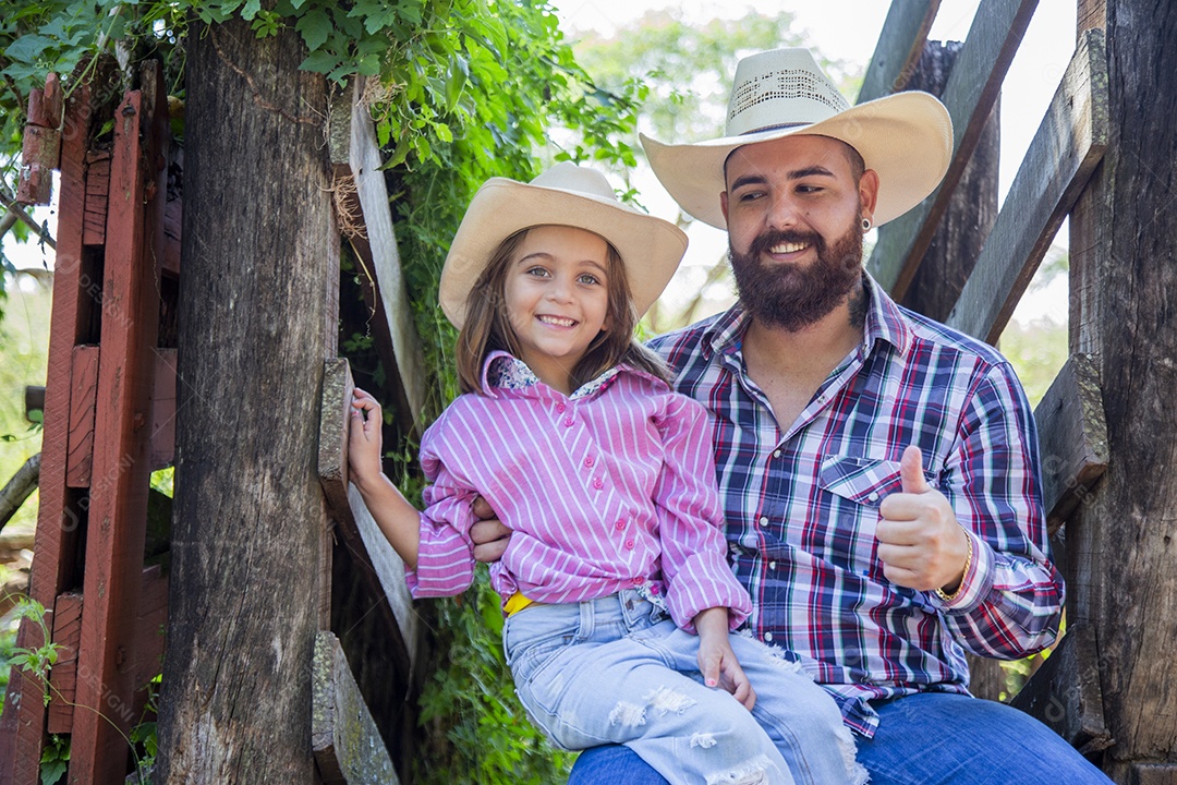 Pai fazendeiro ao lado de sua filha sobre fazenda