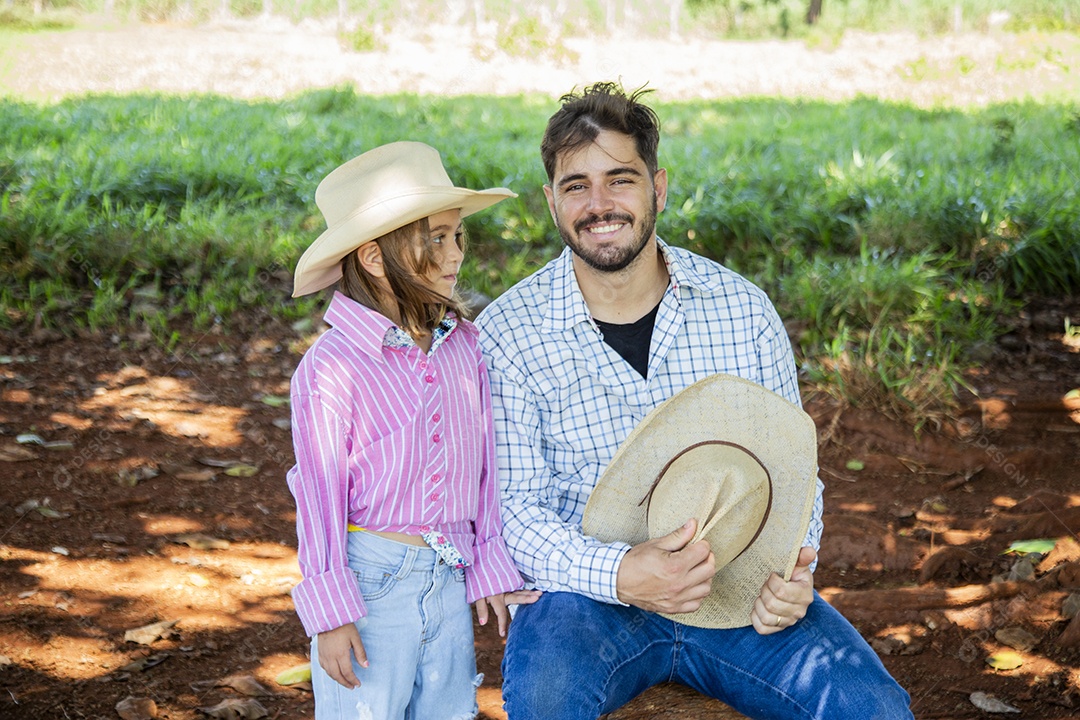 Garotinha ao lado de seu pai fazendeiro sobre fazenda