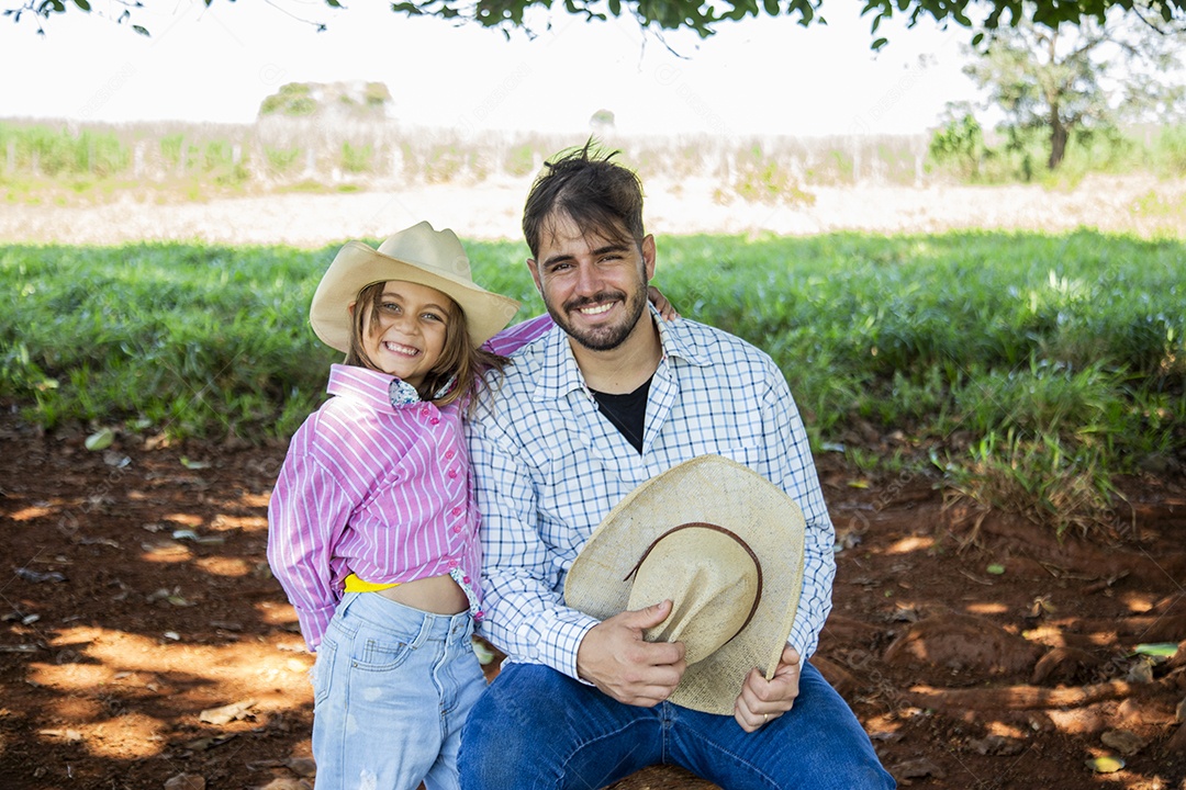 Garotinha ao lado de seu pai fazendeiro sobre fazenda