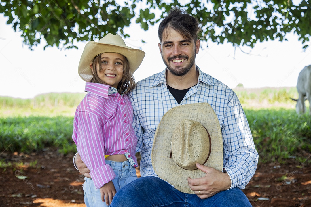 Garotinha ao lado de seu pai fazendeiro sobre fazenda