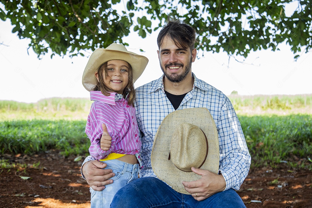 Garotinha ao lado de seu pai fazendeiro sobre fazenda