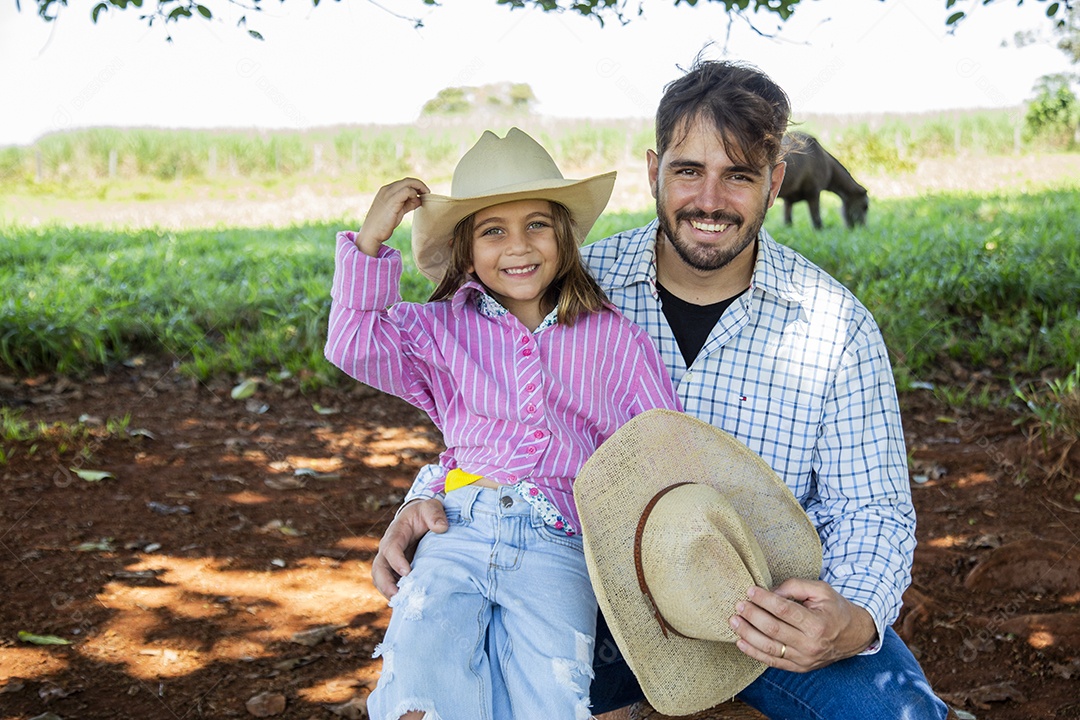 Garotinha ao lado de seu pai fazendeiro sobre fazenda