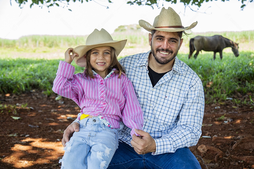 Garotinha ao lado de seu pai fazendeiro sobre fazenda