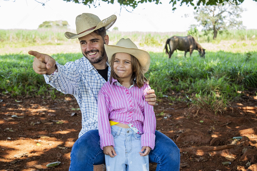 Garotinha ao lado de seu pai fazendeiro sobre fazenda