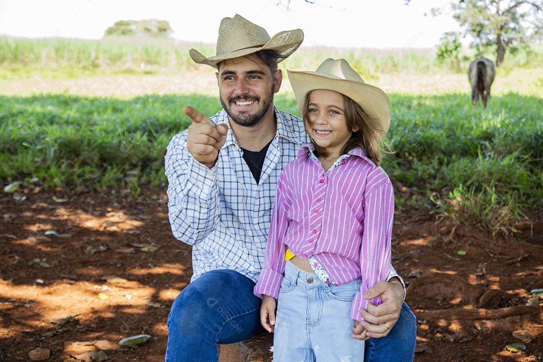 Garotinha ao lado de seu pai fazendeiro sobre fazenda