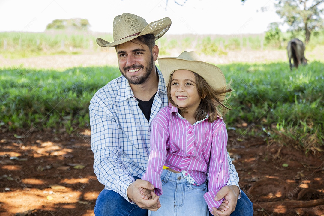 Garotinha ao lado de seu pai fazendeiro sobre fazenda