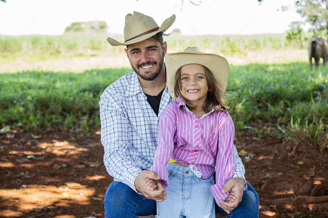 Garotinha ao lado de seu pai fazendeiro sobre fazenda