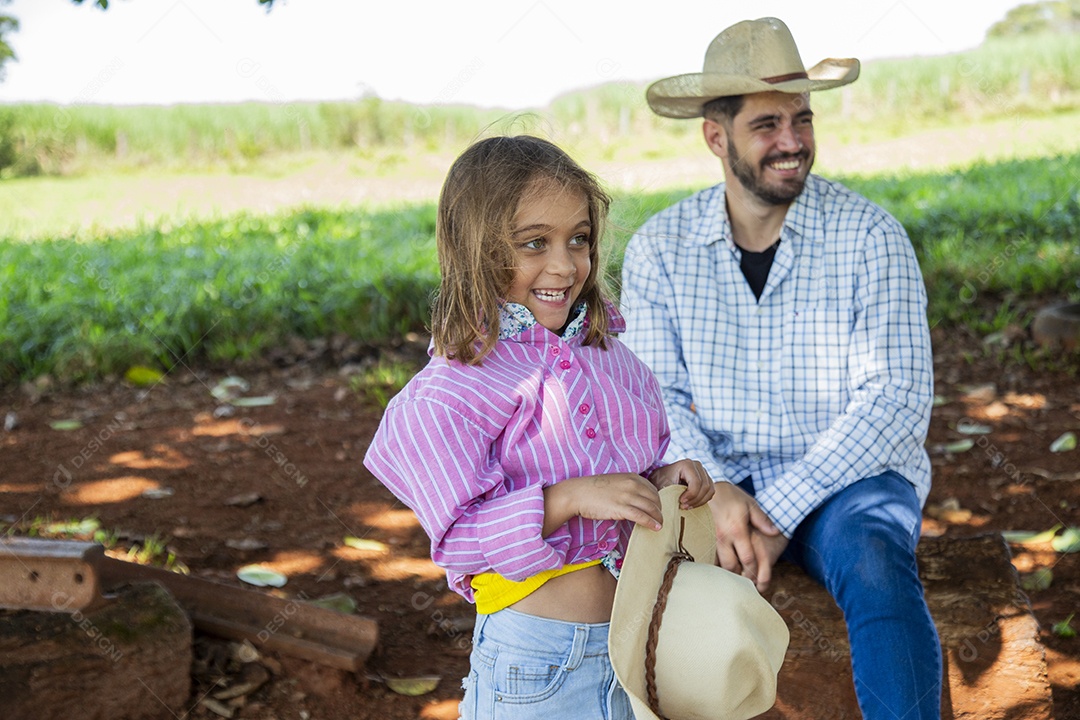 Garotinha ao lado de seu pai fazendeiro sobre fazenda