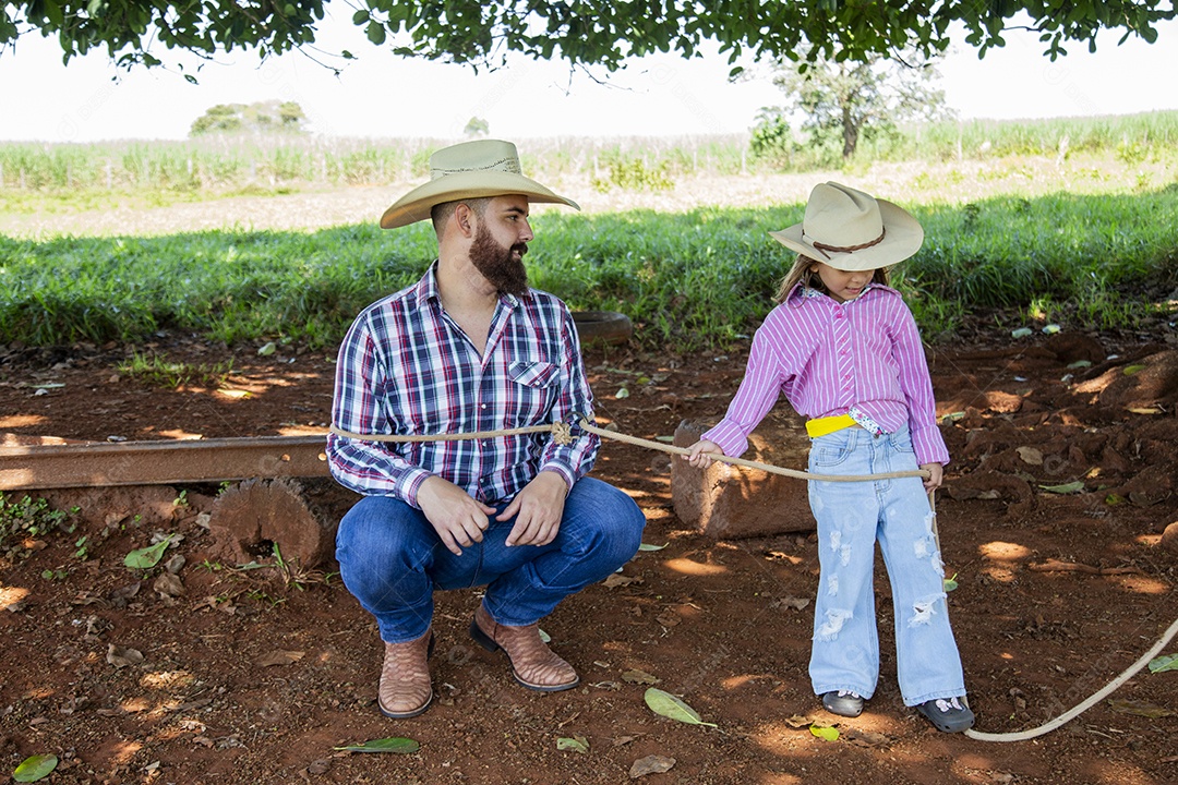 Pai fazendeiro ao lado de sua filha sobre fazenda