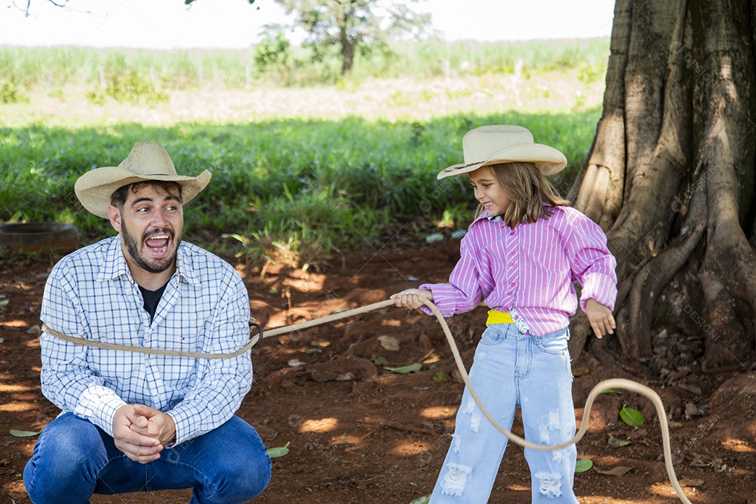 Linda garotinha feliz e sorridente brincando sobre terreno de uma fazenda