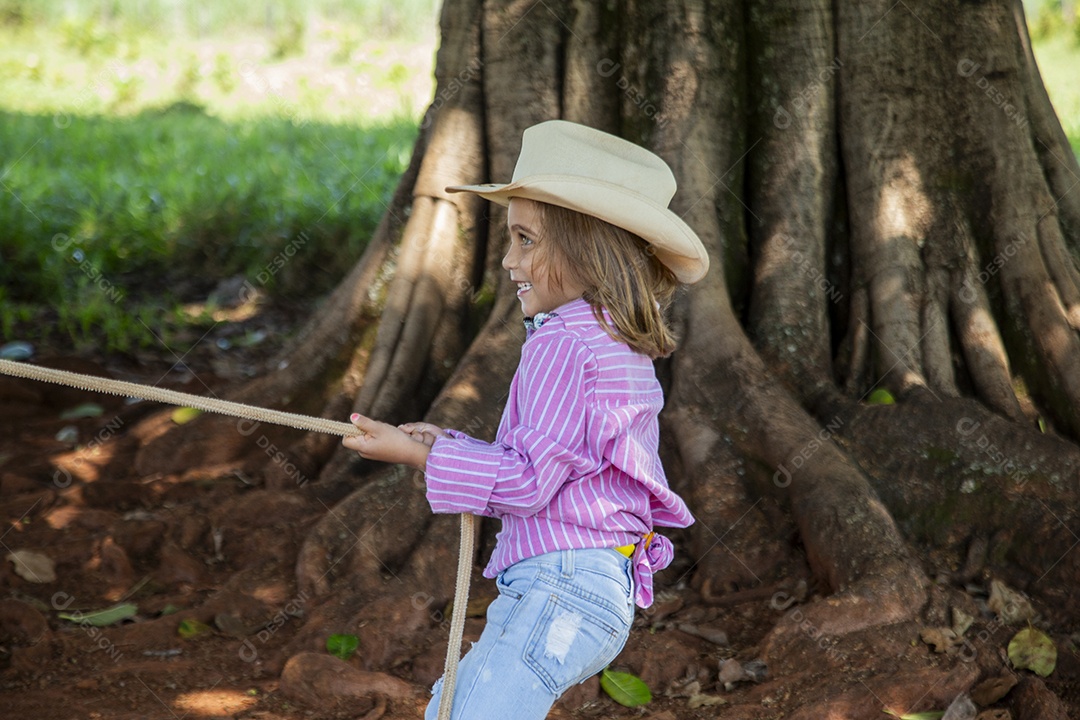 Linda garotinha feliz e sorridente brincando sobre terreno de uma fazenda