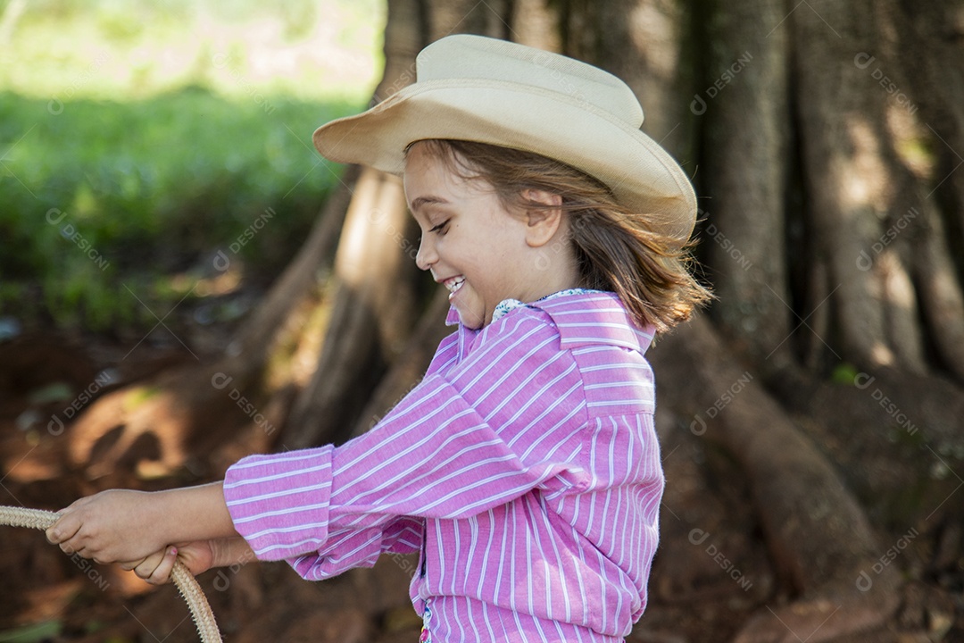 Linda garotinha feliz e sorridente brincando sobre terreno de uma fazenda