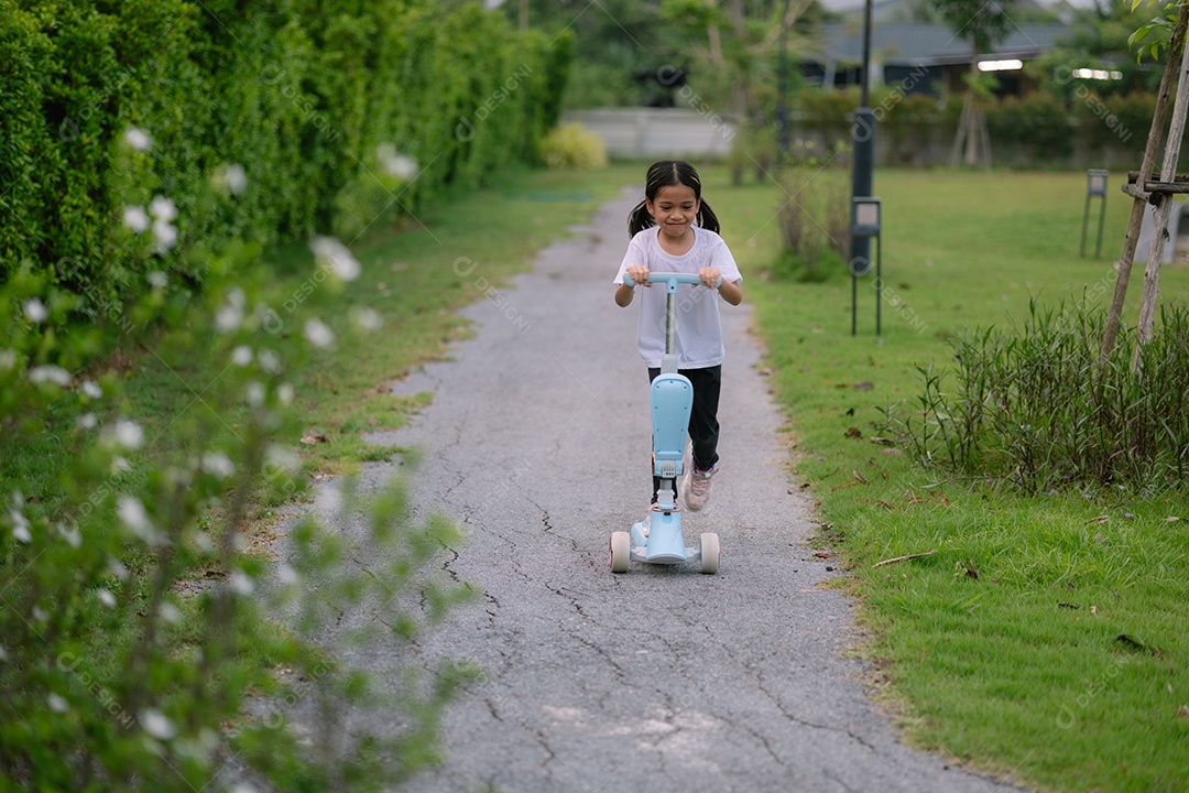 Uma garotinha se divertindo brincando em seu patinete