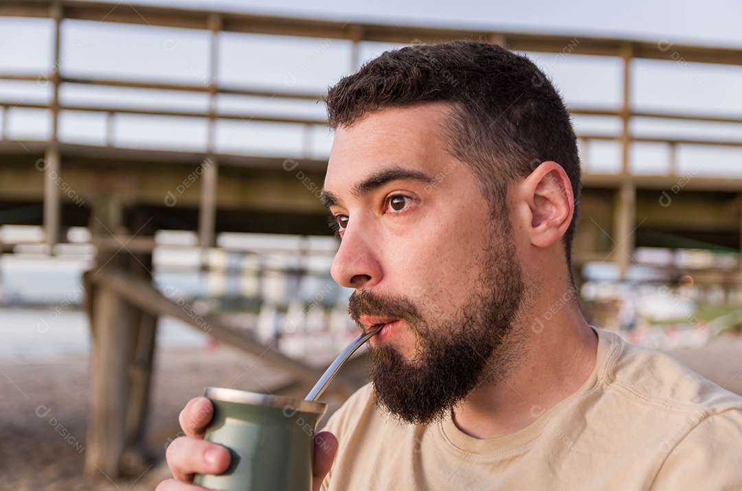 Homem belissímo de barba tomando chimarrão