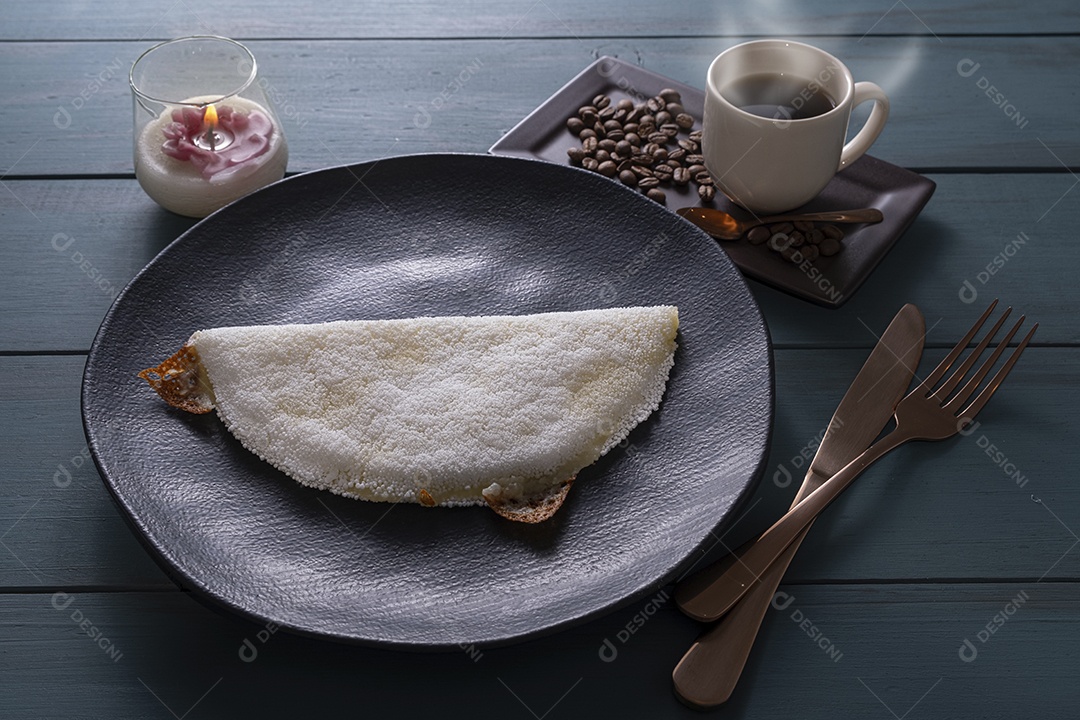 Tapioca com queijo ao lado de xícara de café