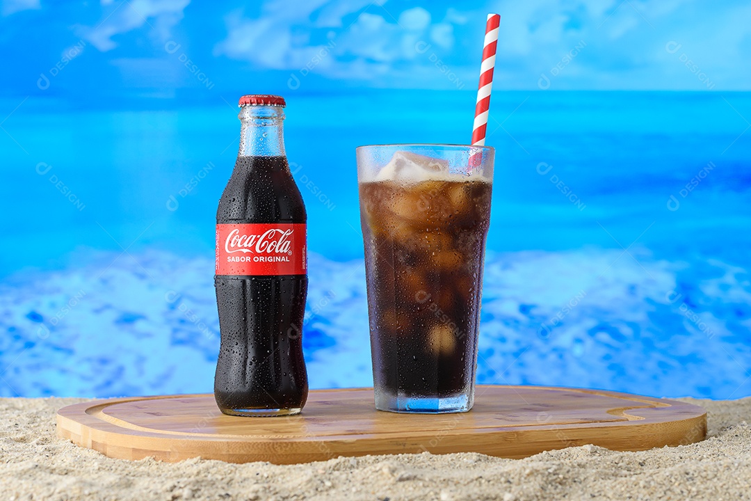 Mini garrafa de coca cola copo com canudo encima da tábua sobre fundo isolado azul