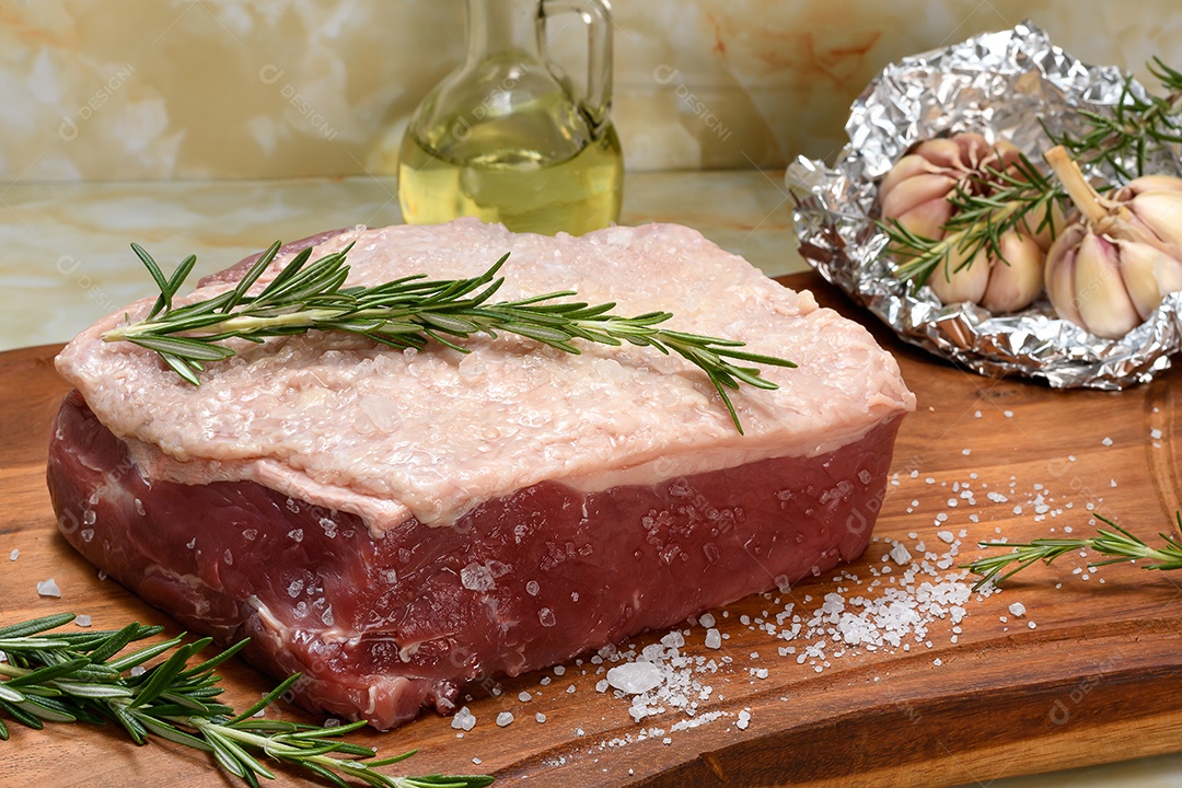 Carne bovina e alecrim sobre a tábua de madeira
