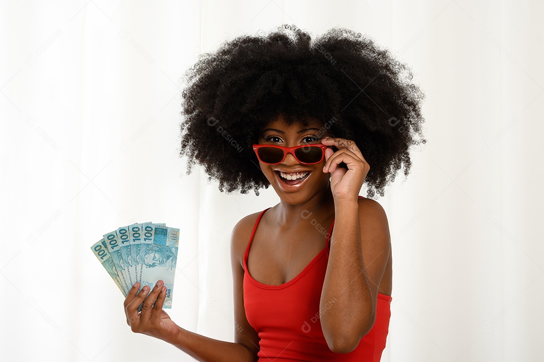 Jovem mulher negra sorrindo segurando notas de dinheiro