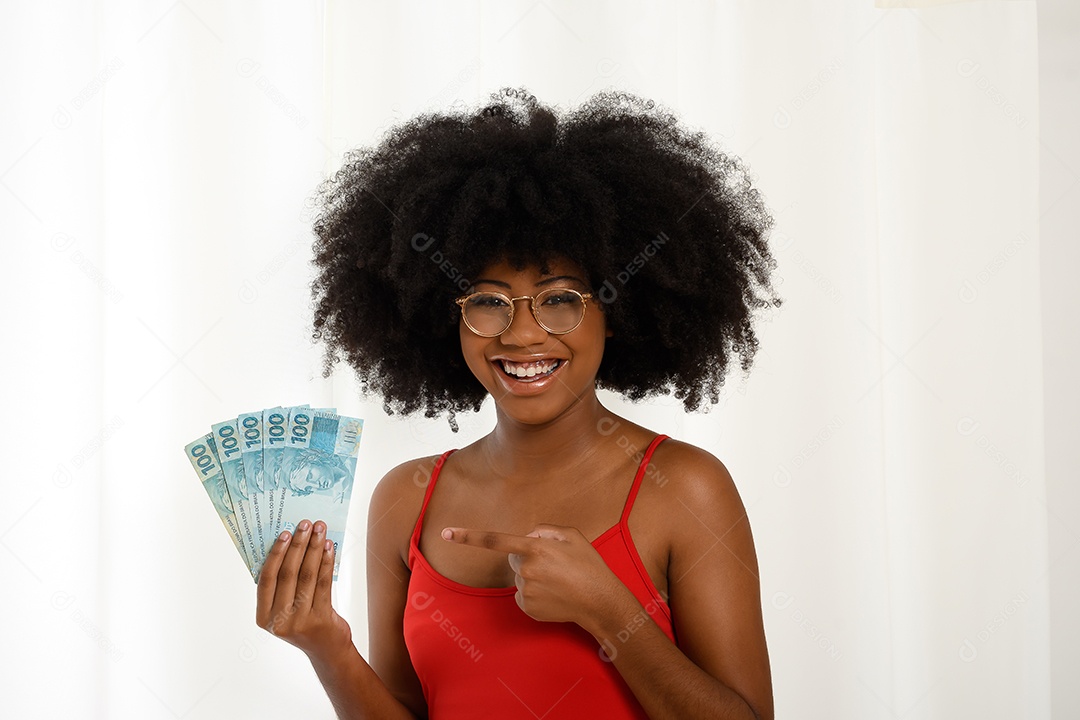 Jovem mulher negra sorrindo segurando notas de dinheiro