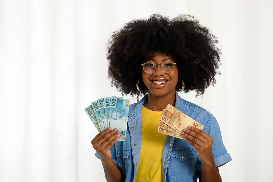 Jovem mulher negra sorrindo segurando notas de dinheiro