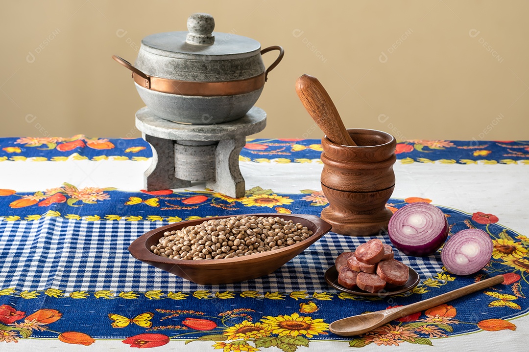 Tigela com feijão outra de calabresa e panela para preparação de feijoada