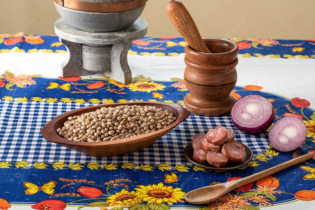 Tigela com feijão outra de calabresa e panela para preparação de feijoada