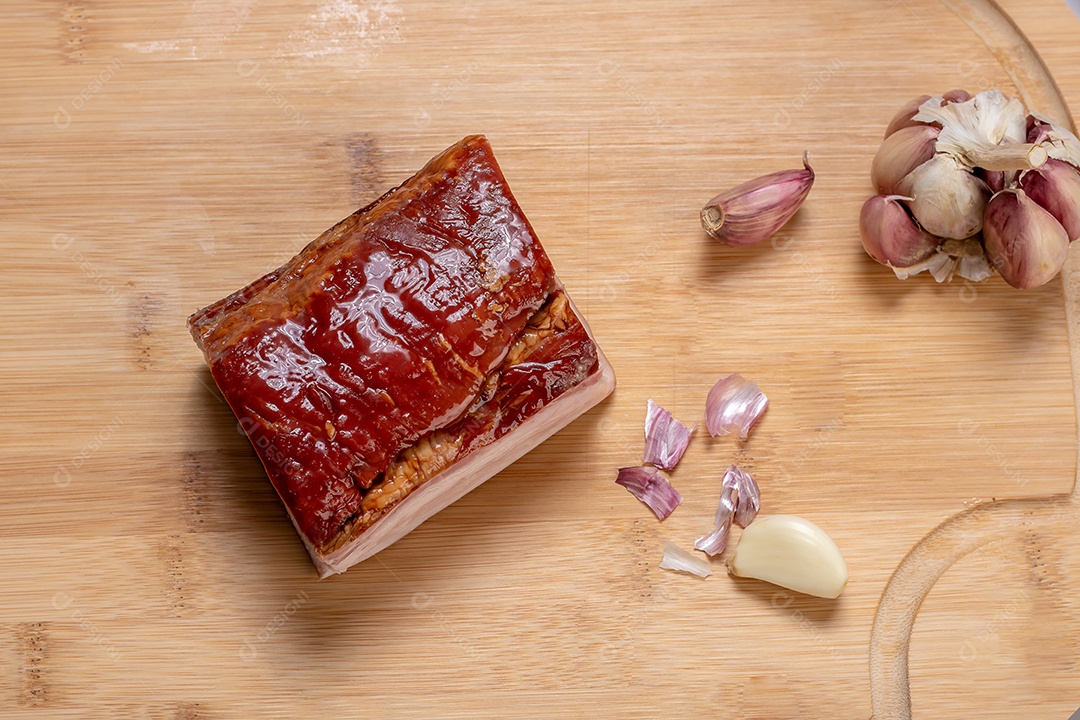 Bacon e alho sobre tábua de madeira