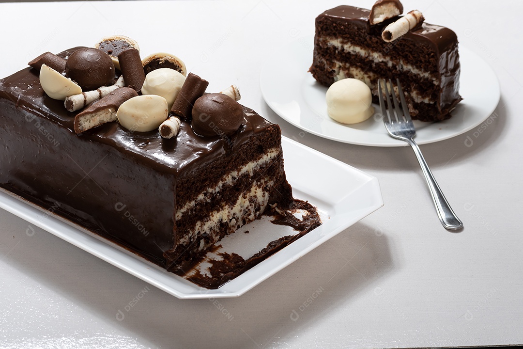 Fatia de bolo de chocolate com recheio de coco e brigadeiros