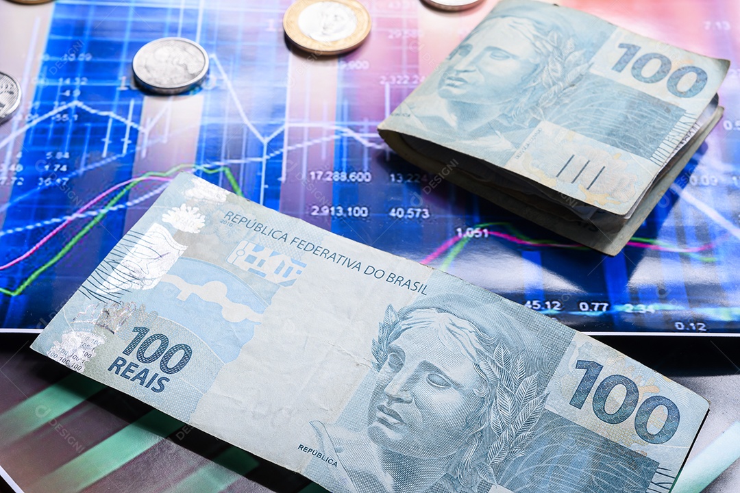 Notas de dinheiro e moedas sobre gráfico financeiro