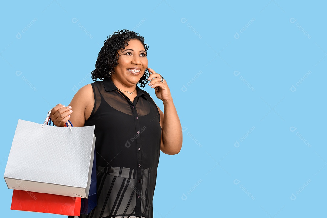Mulher feliz com compras nas mãos falando ao telefone