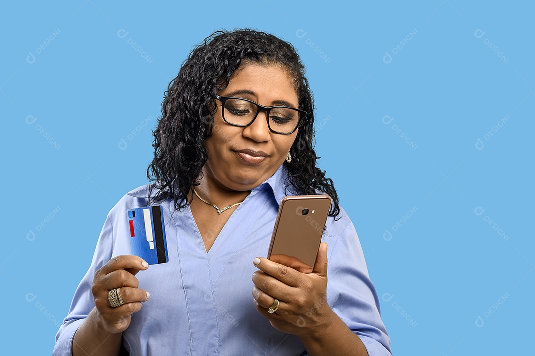 Mulher olhando para celular e com cartão de crédito nas mãos