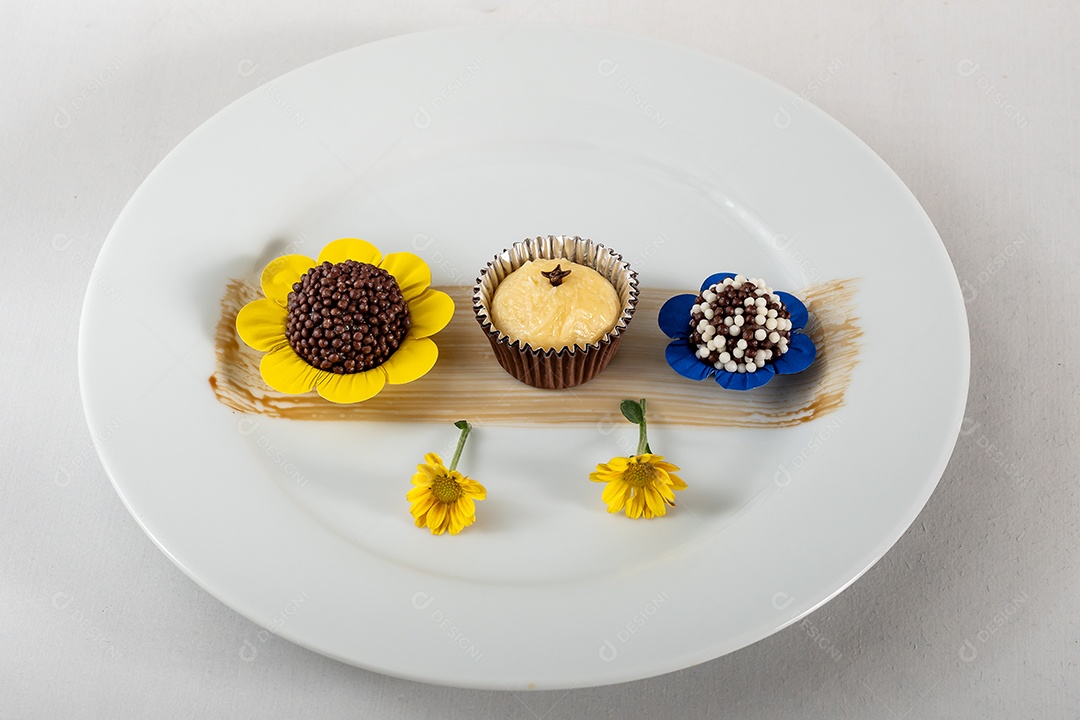 Prato com brigadeiros e beijinhos com flores com decoração