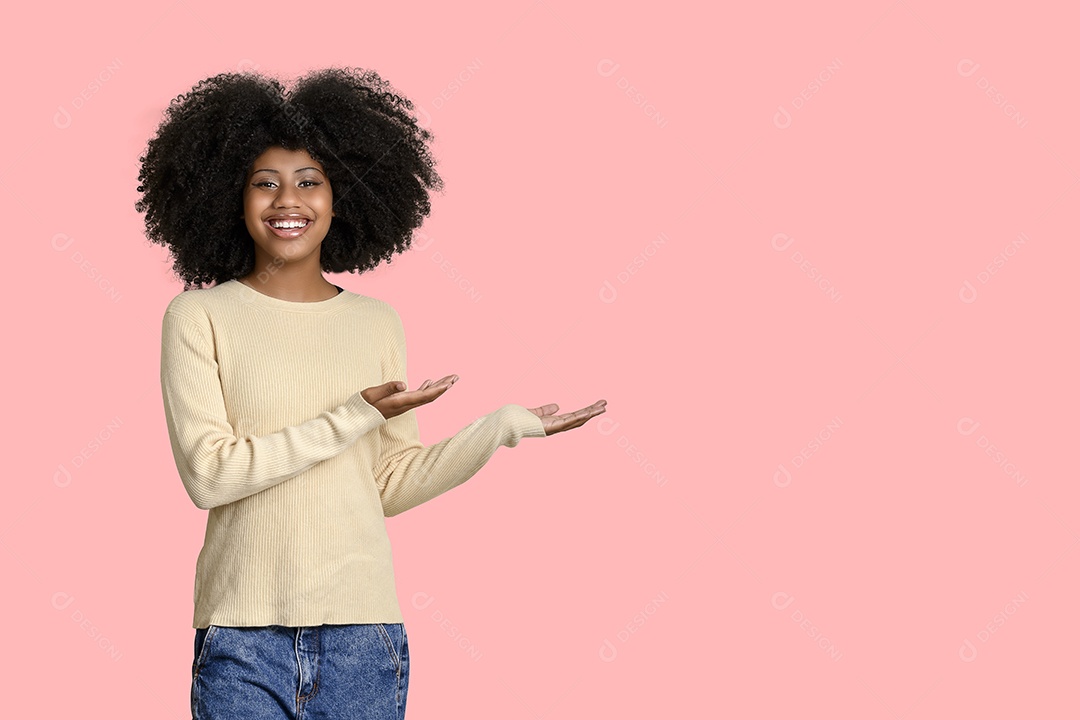 Uma jovem negra com penteado afro apontando algo fundo isolado rosa