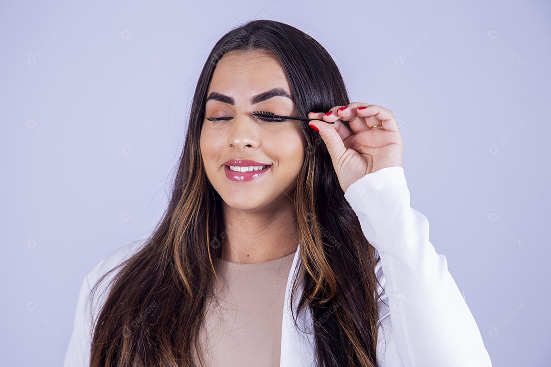 Linda mulher arrumando os cílios sobre fundo isolado