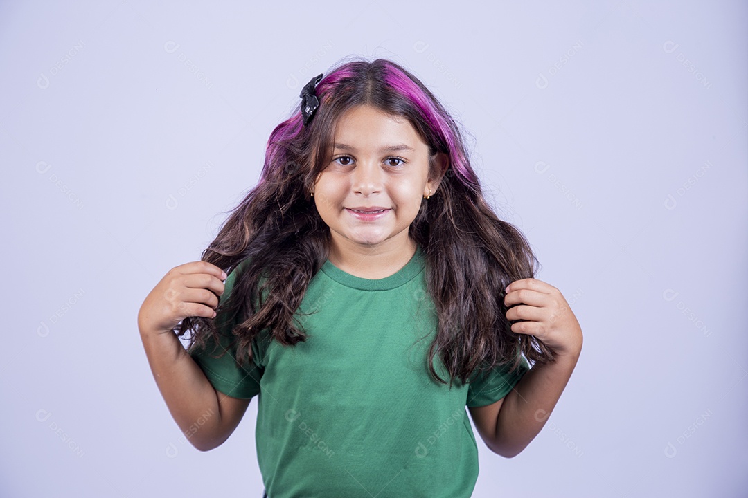 Linda garotinha de cabelos comprindo usando camisa verde.