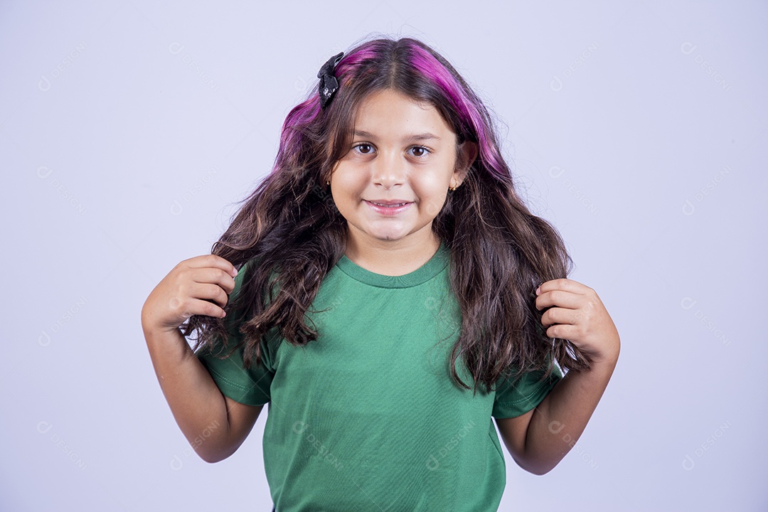 Linda garotinha de cabelos comprindo usando camisa verde.