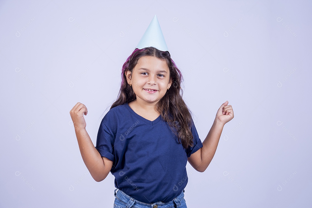 Garotinha com braços erguidos usando chapeu de festa