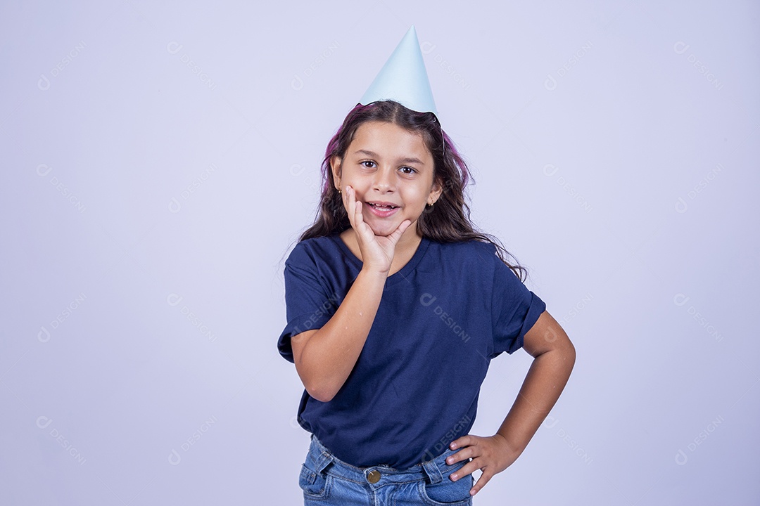 Criança com as mãos sobre a boca usando chapéu de festa infantil sobre fundo isolado