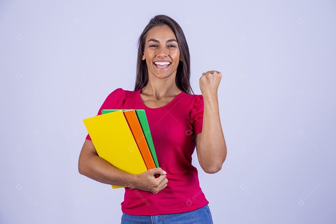 Linda jovem segurando livros coloridos sobre fundo isolado