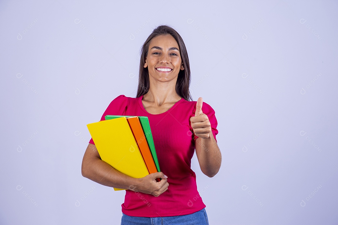 Linda jovem segurando livros coloridos sobre fundo isolado