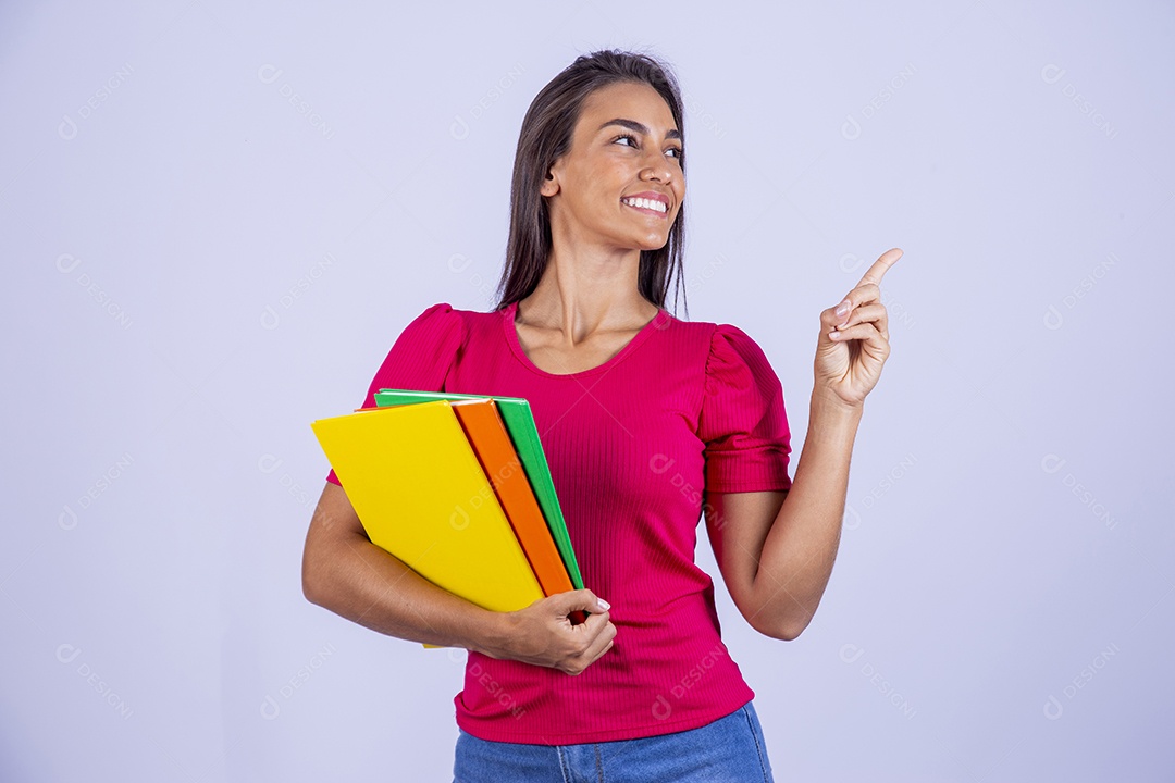 Linda jovem segurando livros coloridos sobre fundo isolado