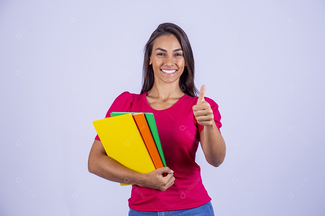 Linda jovem segurando livros coloridos sobre fundo isolado