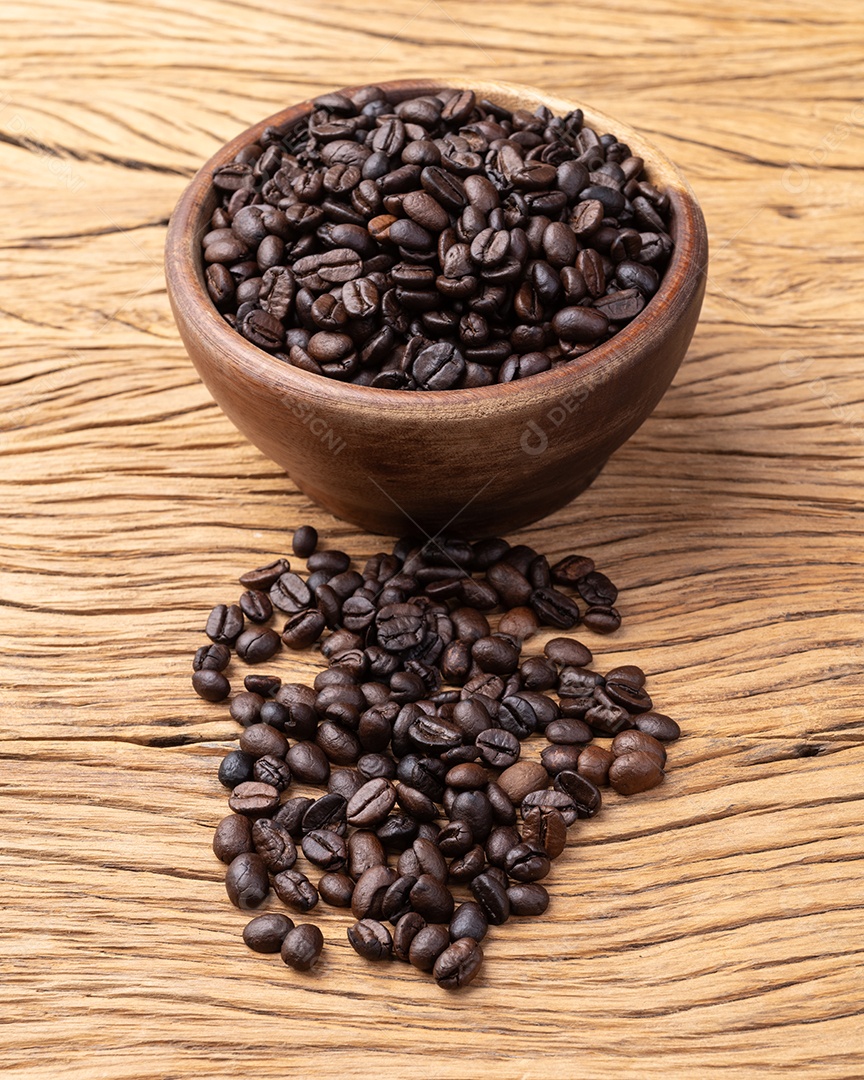 Tigela com café em grão sobre fundo de madeira