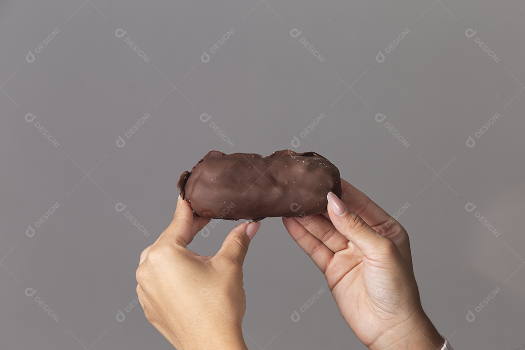 Mão segurando chocolate sobre fundo isoaldo
