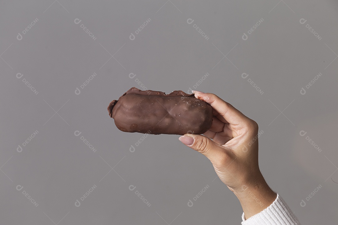 Mão segurando chocolate sobre fundo isoaldo