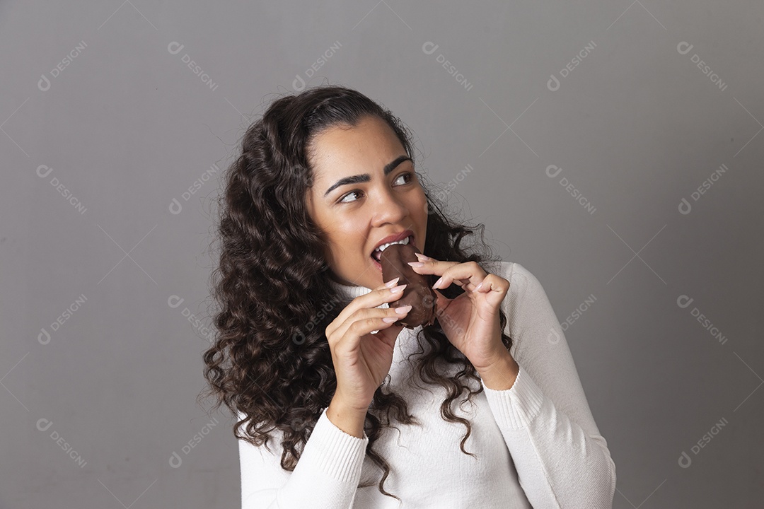 Linda mulher comendo chocolate sobre fundo isolado