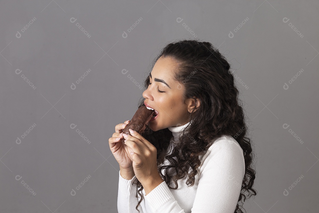 Linda mulher comendo chocolate sobre fundo isolado
