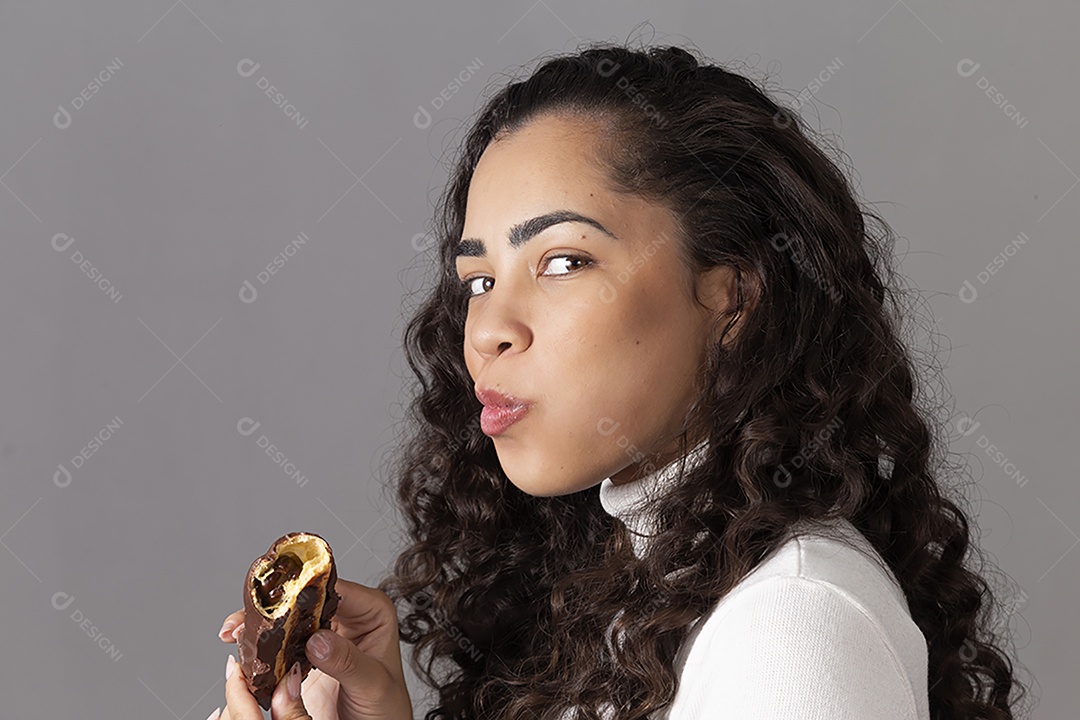 Linda mulher comendo chocolate sobre fundo isolado